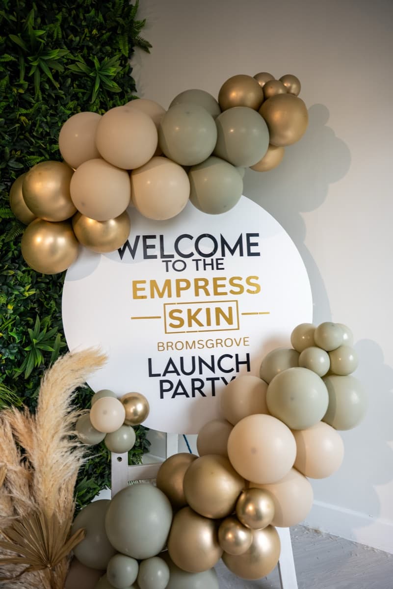 A launch day welcome sign decorated with balloons outside Empress Skin